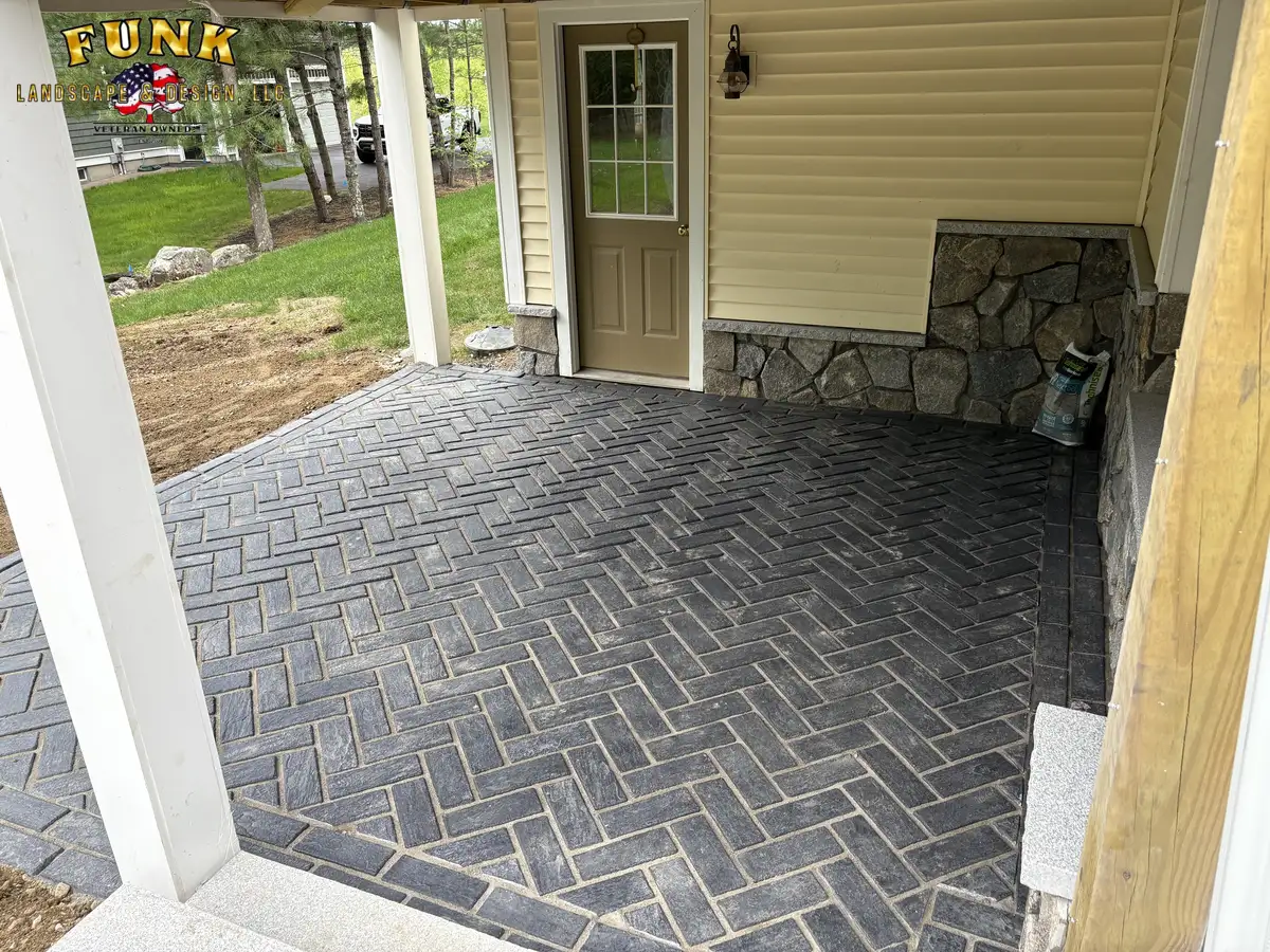Charcoal herringbone paver patio beneath a covered deck