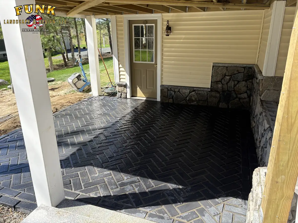 Covered herringbone paver patio with stone accent wall and lattice