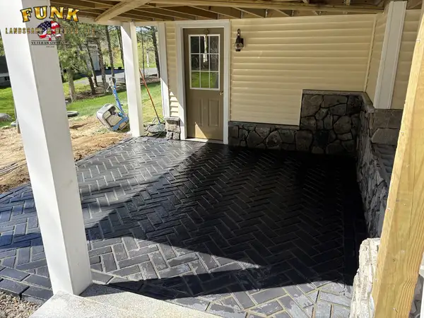 Covered herringbone paver patio with stone accent wall and lattice