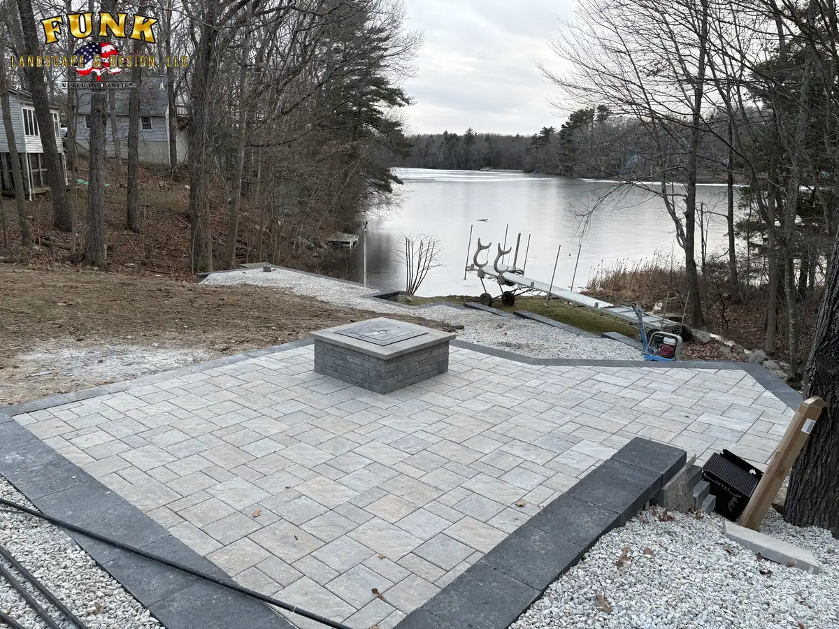 Paver patio with square fire pit overlooking the lake