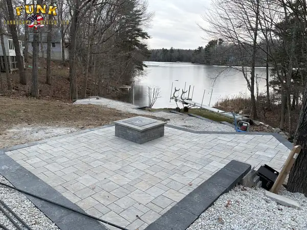 Paver patio with fire pit overlooking the lake, built by Funk Landscape & Design
