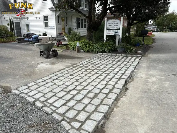 Cobblestone apron installed at the gravel driveway entrance