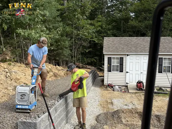 Crew building a block retaining wall course by course