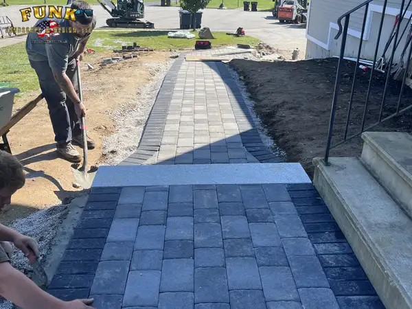 Crew laying the paver walkway at the base of the porch steps