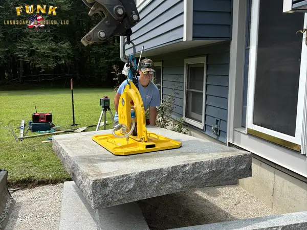 Granite step suspended from a lifter during installation