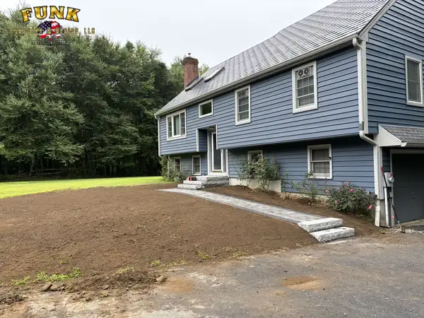 Graded and raked soil around the completed front walkway