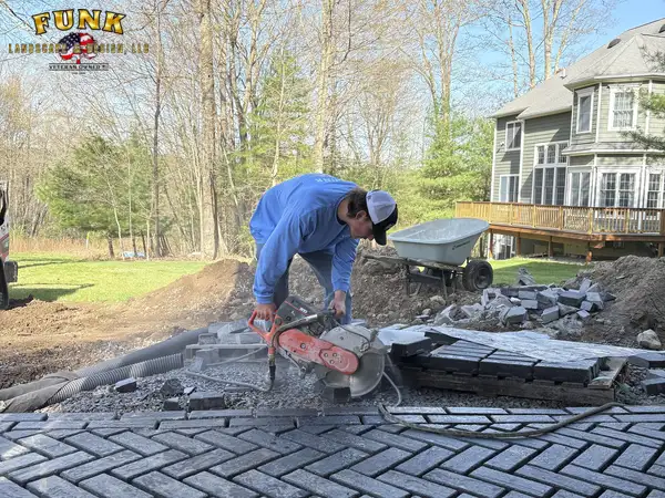 Crew cutting pavers to fit the walkway pattern