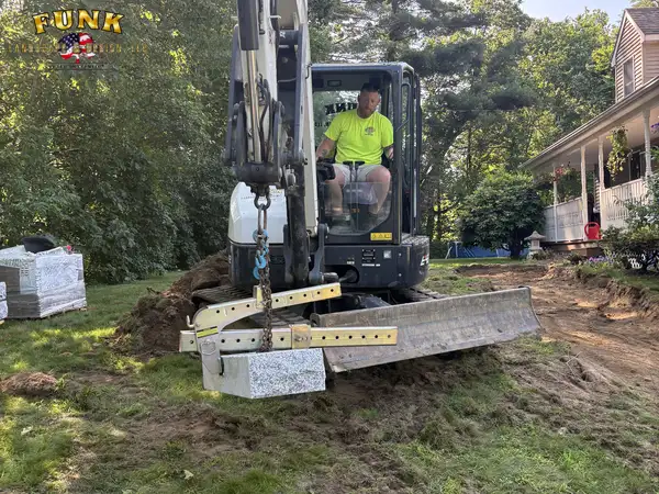 Excavator lifting granite treads into position