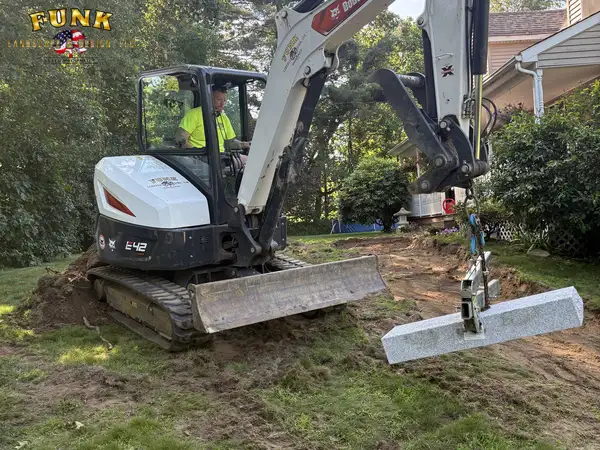 Excavator working close to the house during wall construction