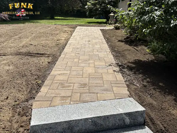 Tan paver walkway with granite edge through the graded yard