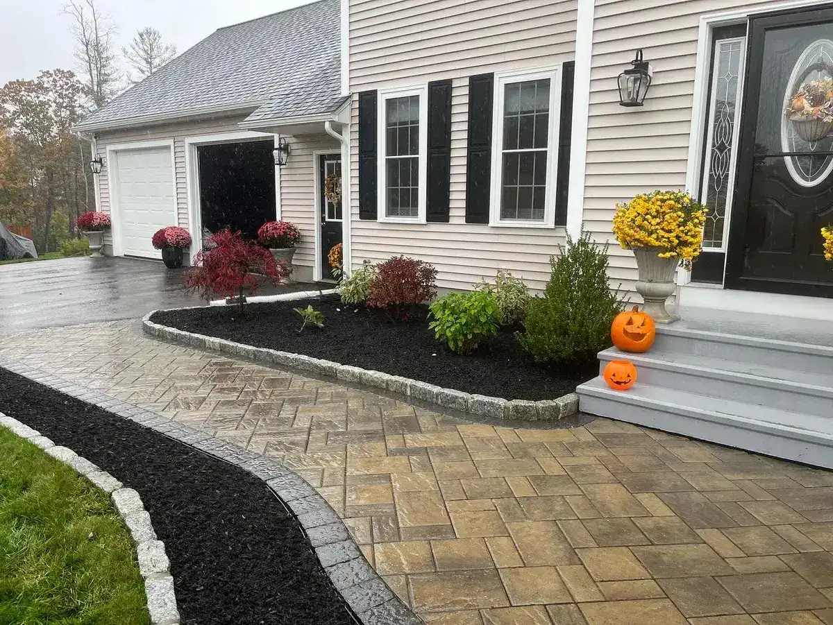 Fresh black mulch beds with cobblestone edging and a new paver walkway installed in Worcester County, MA by Funk Landscape & Design