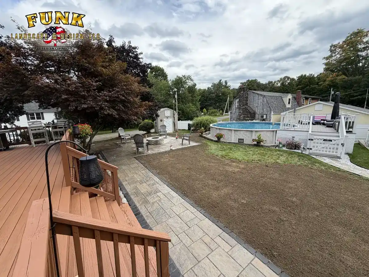 Paver walkway connecting a backyard deck and pool area beside a newly installed lawn by Funk Landscape & Design
